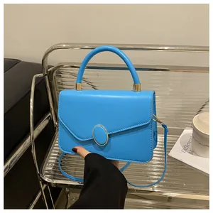 Detailansicht der hellblauen PU-Lederhandtasche mit goldenem Drehverschluss und Griff