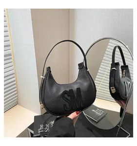 Detail of black textured leather crescent bag with golden zipper and 3D SM logo