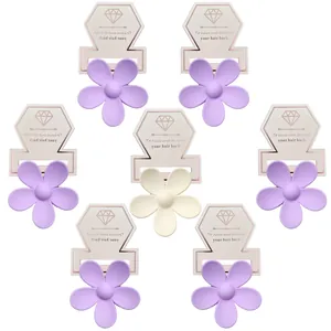 Nahaufnahme matter Blumen-Haarklammern in Lila und Creme auf Kartonverpackung