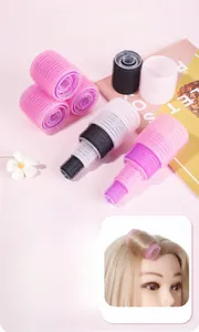 Macro detail of multi-size self-gripping hair rollers in pink, purple, black, and white