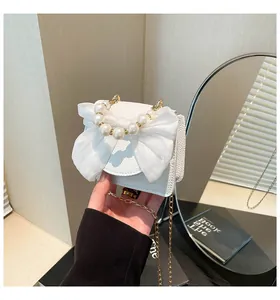 Close-up of white lychee leather bag with pearl handle and mesh bow detail