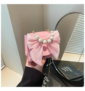 Detail of pink leather mini bag with large mesh bow and round pearl top handle