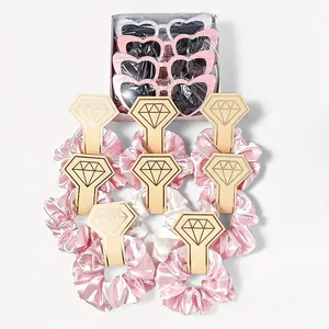 Close-up of pink and white satin hair scrunchies on diamond-shaped gold-edged cards