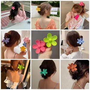 Makroaufnahme bunter matter Blumen-Haarklammern in Pink, Gelb und Lila für das Styling
