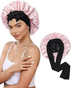 Détail du bonnet de nuit en satin rose avec large bandeau à nœud noir sur modèle