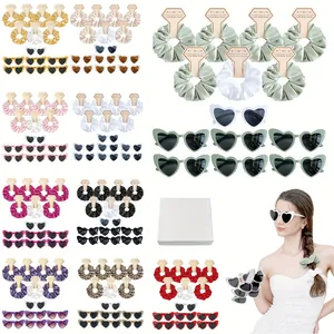 Detail view of satin scrunchies set with heart sunglasses in elegant white gift boxes