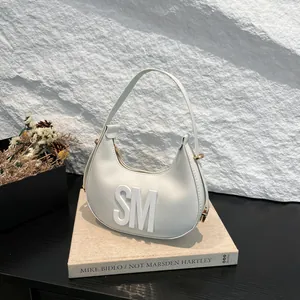 Minimalist beige hobo bag with white SM lettering and elegant golden hardware details