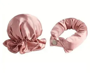 Dettaglio del set cuffia da notte e arricciacapelli in raso rosa con texture liscia