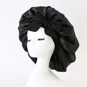 Detailed view of black satin bonnet with oversized bow and smooth silk texture