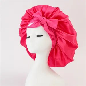 Detailed close-up of a rose red satin bonnet featuring a large bow and elastic edge