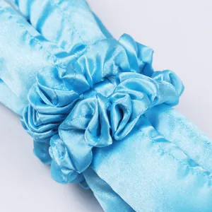 Détail du bigoudi sans chaleur en satin bleu clair et chouchou assorti à texture soyeuse