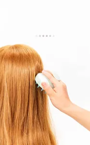 Action shot of an ergonomic green silicone scalp massager brush for hair washing