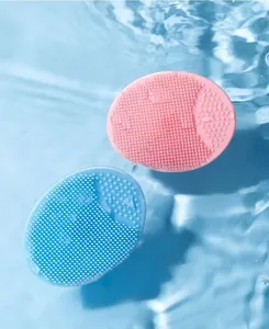 Close-up of pink and blue silicone scalp brushes for babies in refreshing water ripples