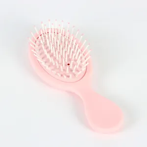Detail der rosa Minibürste mit Massageborsten und ergonomischem Griffdesign