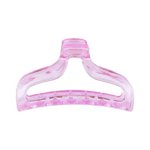 Detail of pink translucent hair claw clip with wavy design and smooth resin finish