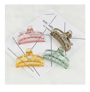 Detail view of transparent rectangular hair claws in pink, yellow, green and coffee tones