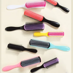 Set di spazzole colorate a 9 file per districare e acconciare su sfondo beige