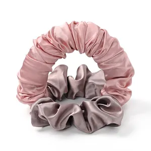 Dettaglio degli elastici per capelli scrunchie in raso rosa e color champagne