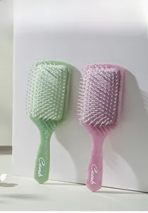 Detail of light green and pink air cushion hair combs with elegant lace patterns