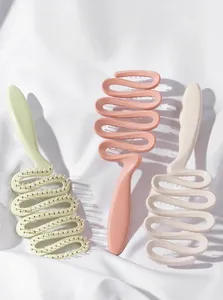 Spazzole per capelli ventilate a forma di S in verde, rosa e beige su tessuto