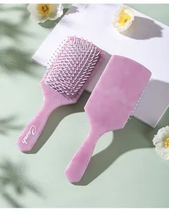 Detailed view of pink floral hair brush with massage bristles on desktop background