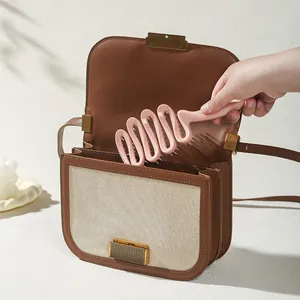 Spazzola rosa portatile a forma di onda riposta in borsa per l'uso quotidiano