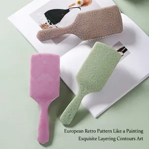 Square totem air cushion hairbrush in pink, green, and brown with vintage patterns