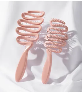 Dettaglio di spazzole per capelli rosa traforate con design a onde su tessuto
