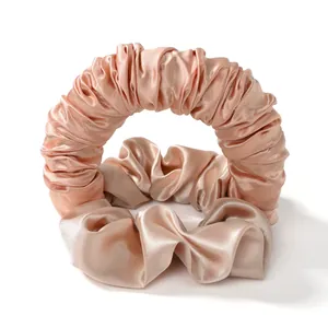 Set bigodini senza calore in raso oro champagne con due elastici in seta su sfondo bianco