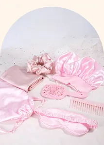 Pink seven-piece hair care set featuring satin bonnet, eye mask, and massage combs
