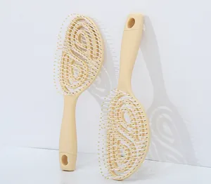 Detail of the spiral hollow vent design and massage bristles on the beige hair brush