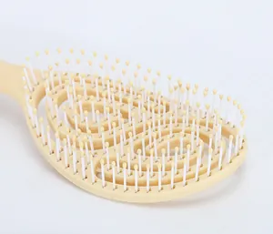 Detail of hollow vented hairbrush showing flexible plastic wavy design and massage bristles