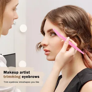 Close-up of a pink eyebrow razor with micro-guards used by a professional makeup artist
