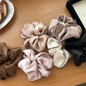 Elastici per capelli in raso stile francese in tonalità terra su tavolo in legno