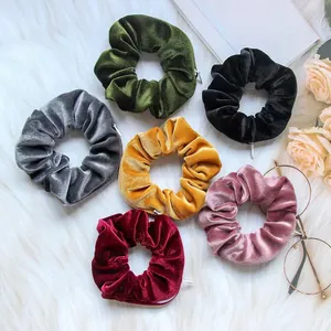 Velvet scrunchies set with hidden zipper pocket for small storage on plush background