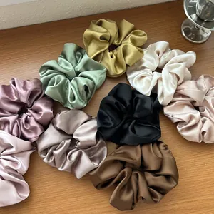Set di elastici per capelli in raso setoso in vari colori su sfondo di legno