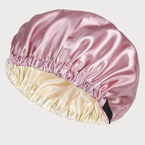 Detail of double-layered pink satin sleep cap with adjustable button and silky texture