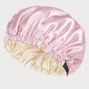 Detail showing high-gloss pink satin sleep bonnet with adjustable elastic band and beige lining