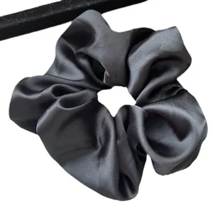 Elegante elastico per capelli in raso nero con texture setosa su uno sfondo bianco