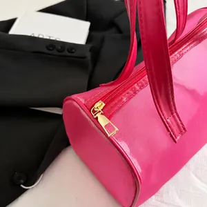 Dettaglio borsa shopper in rete rosa acceso con cerniera dorata e manici piatti