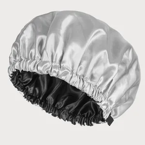 Detail of double-layer satin sleep cap showing silver outer fabric and black inner lining