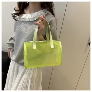 Detailweergave van een fluorescerende groene mesh emmer-tas met lederen handvatten en rits
