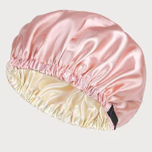 Detail of double-layer satin sleep bonnet showing pink exterior and adjustable buckle
