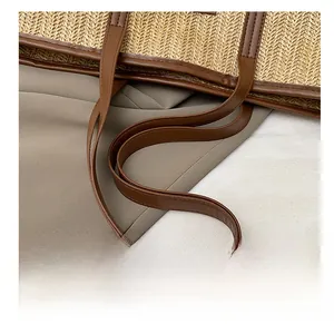 Détail de la bandoulière en cuir PU marron et texture paille tressée du sac fourre-tout