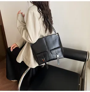 Détail du grand sac cabas vintage noir avec deux poches avant à boucles et finitions argentées