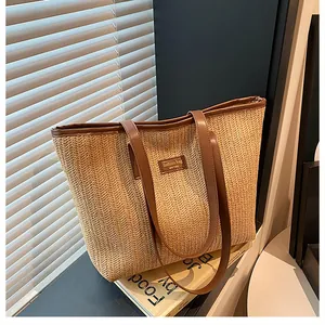 Détail du tissage en chevrons et de l'étiquette en cuir marron sur le sac en paille