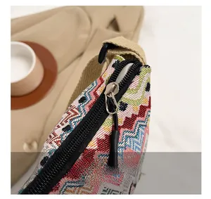 Detailed close-up of smooth zipper and textured ethnic geometric canvas fabric