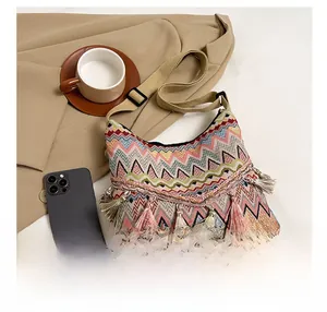 Close-up of bohemian canvas crossbody bag with colorful patterns and tassel details