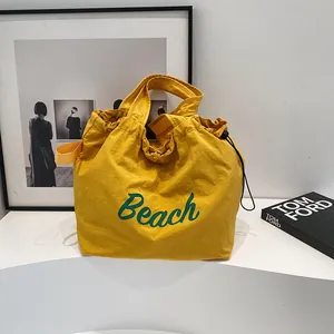 Sac fourre-tout en toile délavée jaune avec lettrage Beach et cordon de serrage