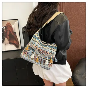 Ethnic hobo bag with colorful geometric stripes and tassels shown on a model